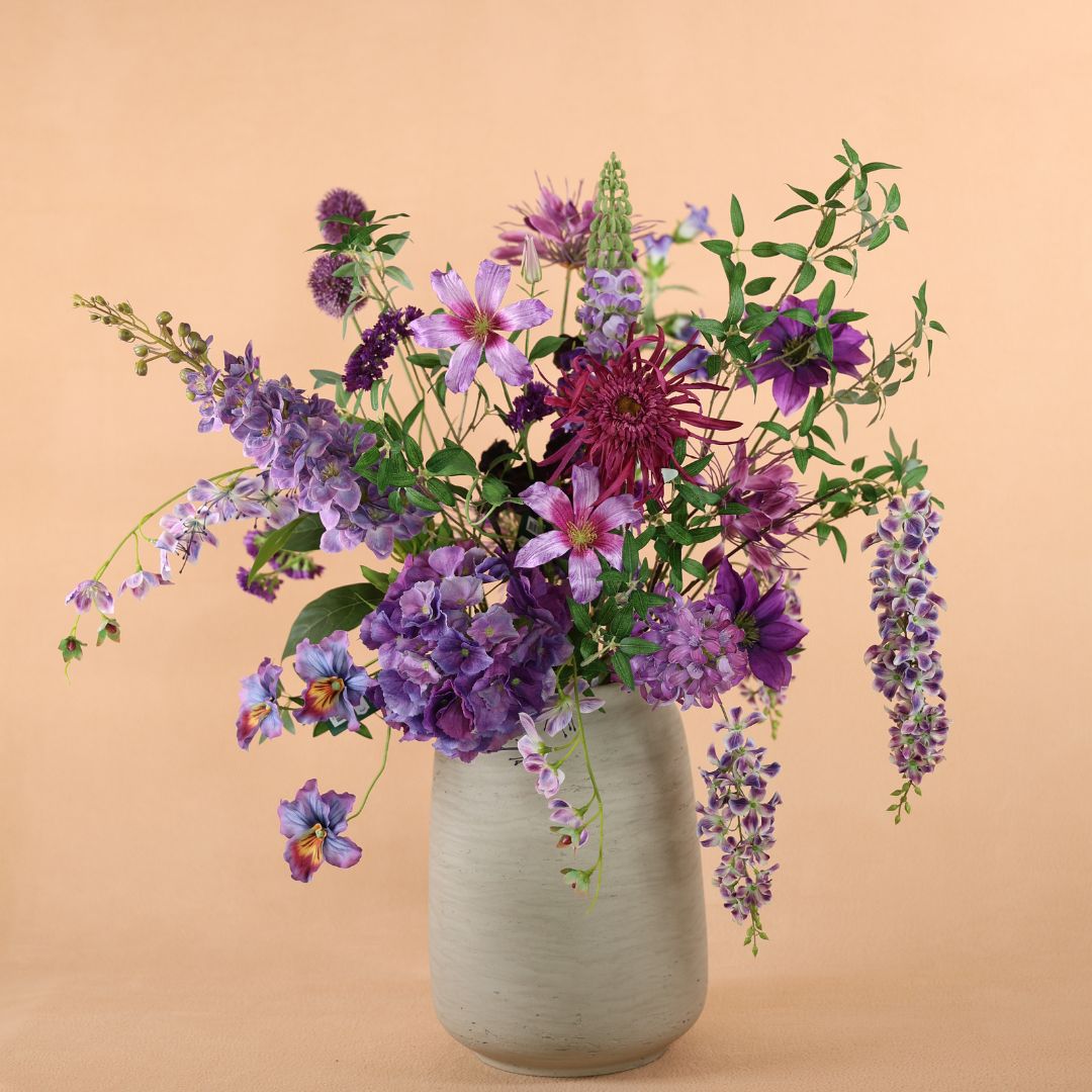 Beige vaas met zijden bloem boeket paars