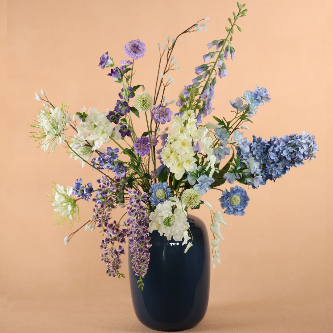 Blauwe vaas met zijden bloem boeket wit blauw paars