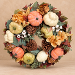 Herfstkrans Soft Pumpkin met crème en perzikkleurige pompoenen op beige achtergrond