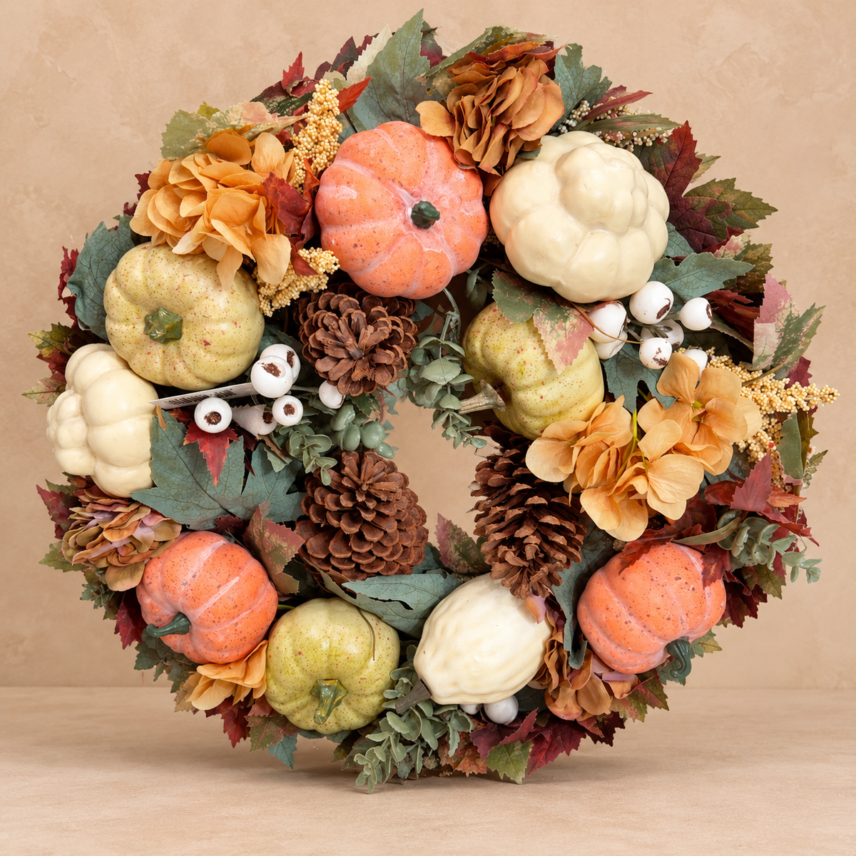 Herfstkrans Soft Pumpkin met crème en perzikkleurige pompoenen op beige achtergrond