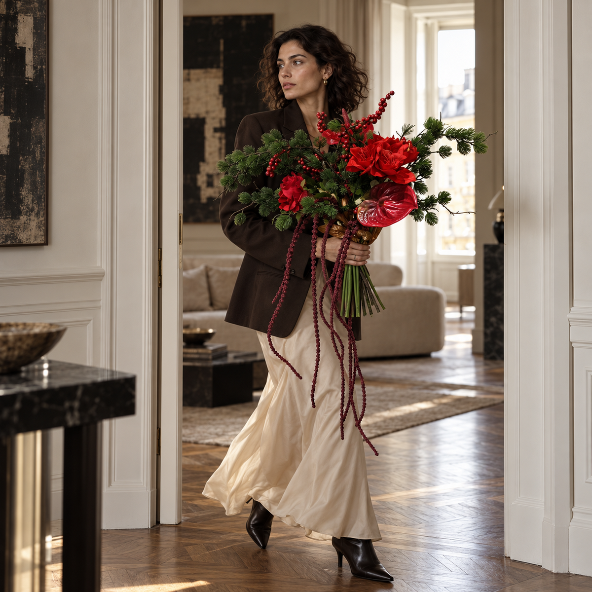 Model draagt zijden boeket Crimson Cascade met rode bloemen en lange bordeaux hangende takken zonder vaas door een hal