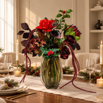 Velvet Noël: rood-bordeaux zijden kerstboeket met groen hulstblad, rode bessen en lange hangende takken in olijfgroene geribbelde vaas, kersttafel