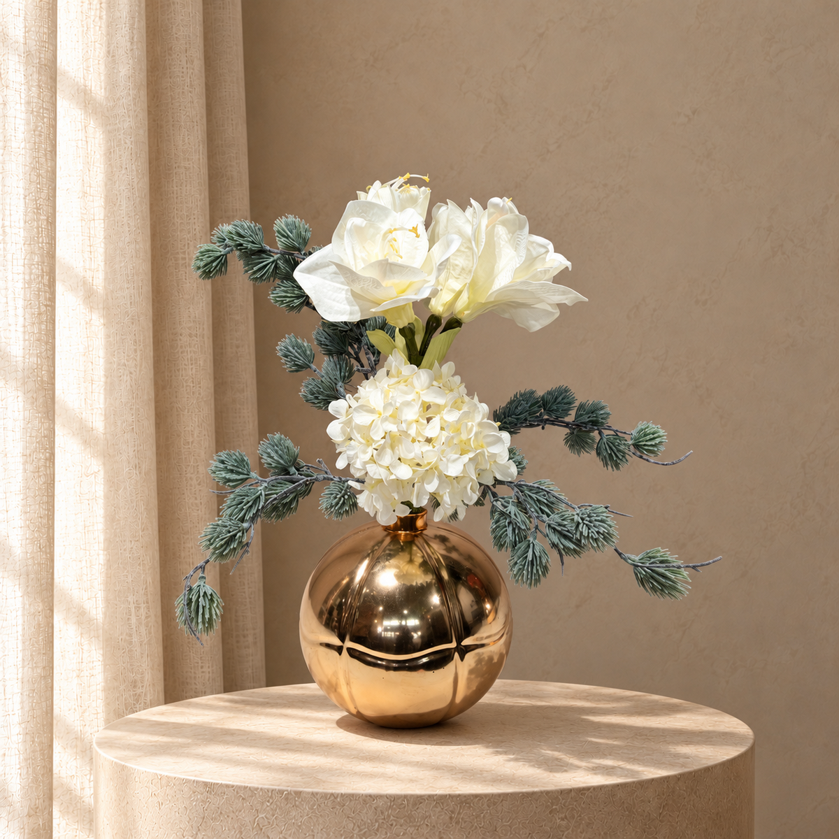 Zijden kerstboeket Ivory Glow met witte amaryllis, witte hortensia en grijsgroen wintergroen in gouden bolvaas op beige studioachtergrond