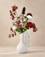 Zijdenboeket Burgundy Cascade inclusief witte vaas op warme beige achtergrond
